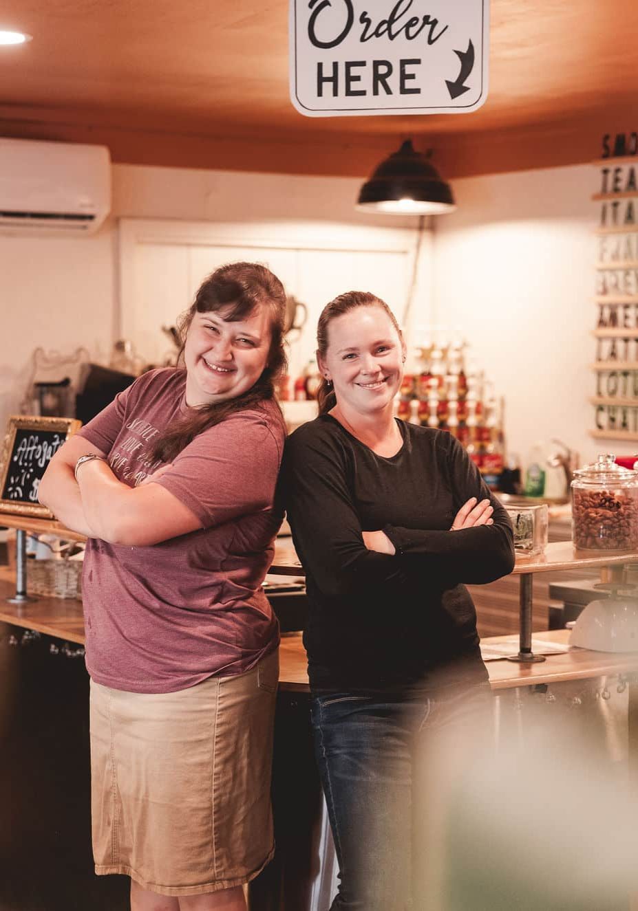 Janessa and Anna standing back-to-back smiling at the camera.